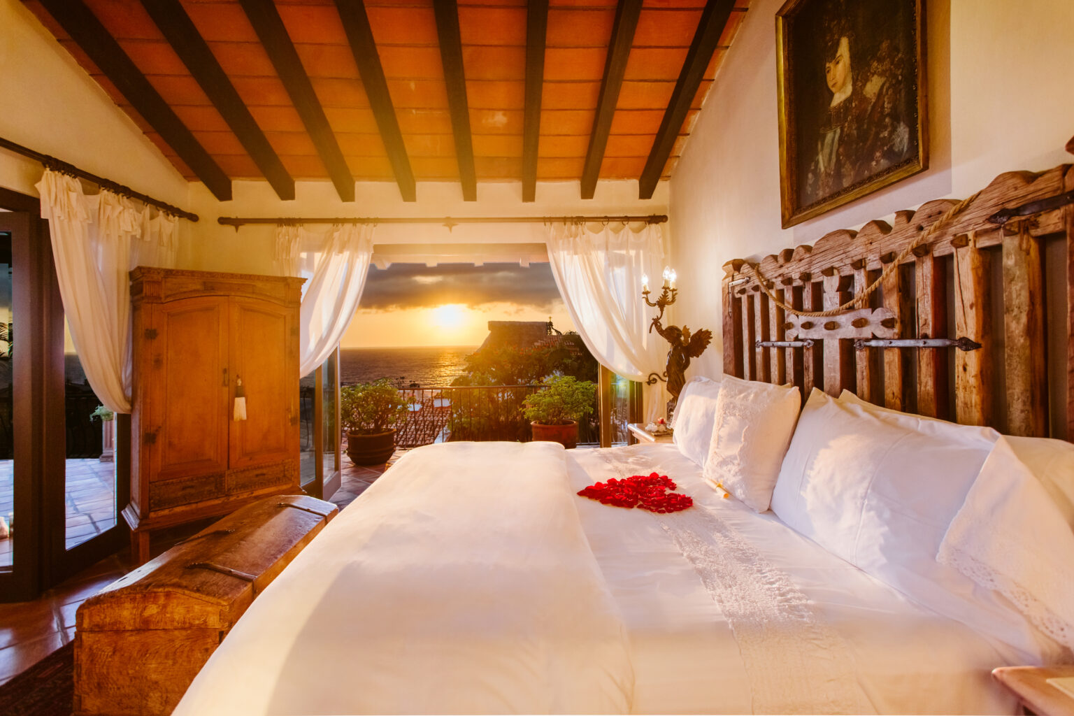 San Miguel Presidential Suite bed with heart made of rose petals and sunset view