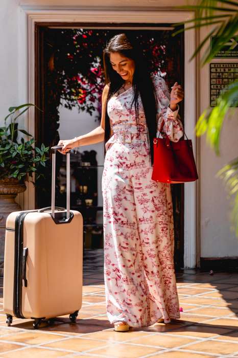 reservation policy showing concierge assist happy guest in white and red dress arriving with luggage