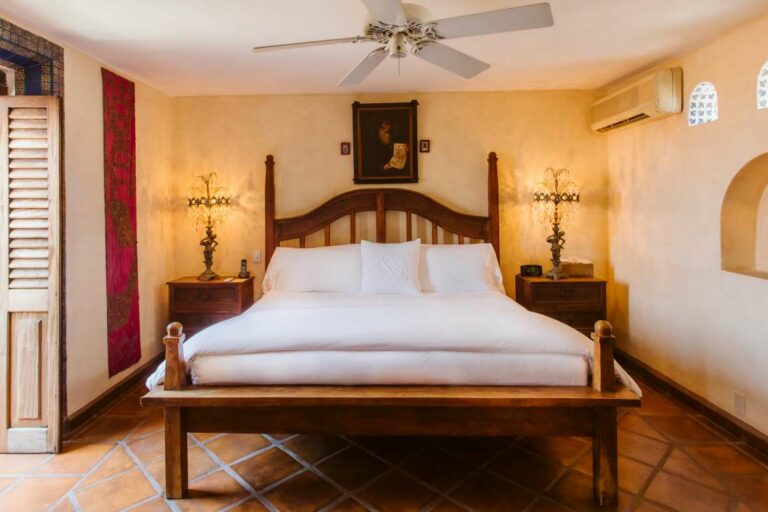 Milagros Suite feature head on close up of bed with large wooden frame.