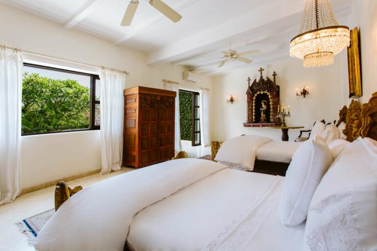 San Gabriel Suite feature photo with two beds, large wooden armoire and open window.