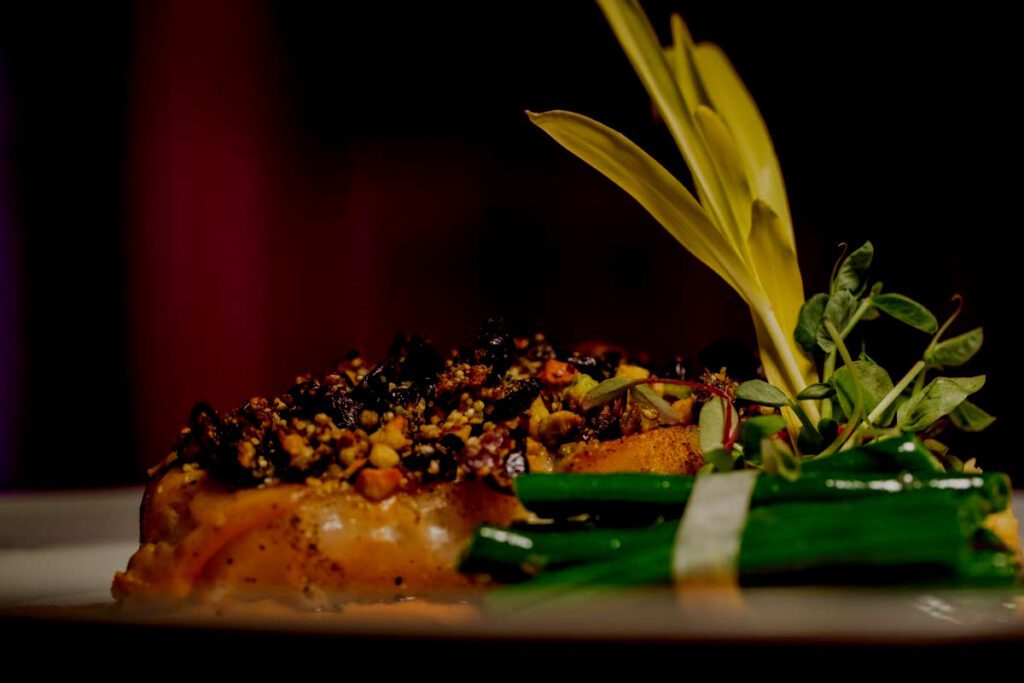 Hacienda San Angel Gourmet entreé of encrusted wild salmon, a bundle of asparagus with endive and watercress garnishments.